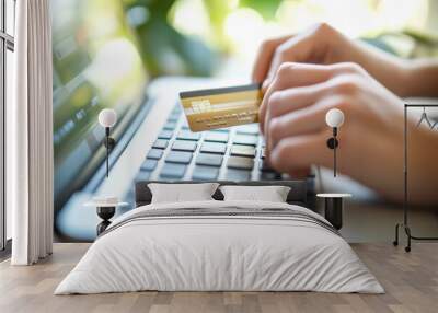 Person typing credit card details on laptop for online payment. Wall mural