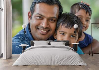 Portrait of a South Asian father smiling with his two children in a park, depicting a joyful family moment. Wall mural