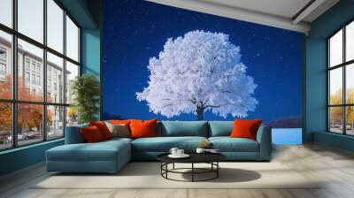 Snow-covered tree under starry night sky. Wall mural