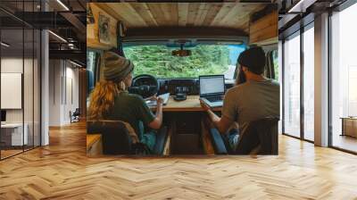 Two people in van, browsing on computer. Wall mural