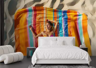 Vibrant celebration of summer as a Latin American woman stretches with a colorful towel on the beach. Wall mural