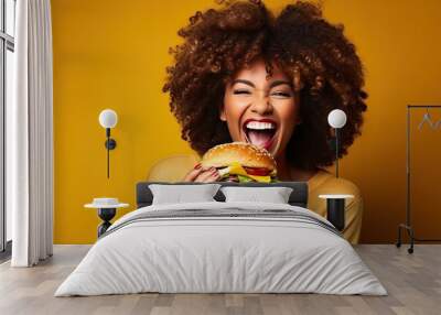 woman eating a hamburger. Person eating a sandwich. black woman eat burger on yellow background Wall mural