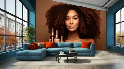 Woman with curly hair holding skincare products on a neutral background, concept of beauty Wall mural