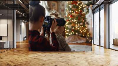 Young children capturing magical Christmas moments with a camera, in front of a beautifully decorated tree Wall mural