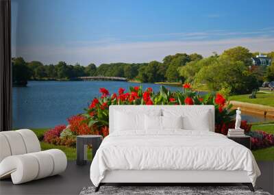 A beautiful, blooming summer garden sits at the edge of a serene lake Wall mural