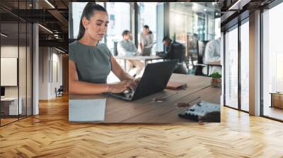 Business woman on a computer at a startup company, working on email. Girl in corporate management at a desk on the internet in tech office or a web designer learning to design a website on a laptop. Wall mural