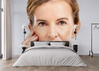 Face, beauty and skincare with a mature woman posing for antiaging treatment in studio on a gray background. Portrait, wellness and wrinkles with a model female inside to promote a natural product Wall mural