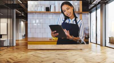 Female cafe or small business manager on phone call, reading a digital tablet in her store. Startup business woman, entrepreneur or employee working in a coffee shop preparing online grocery sales Wall mural