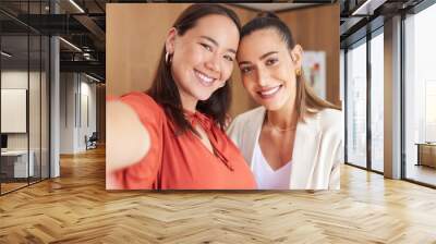 Great collaborations lead to great friendships. Shot of two young coworkers taking a selfie at work. Wall mural