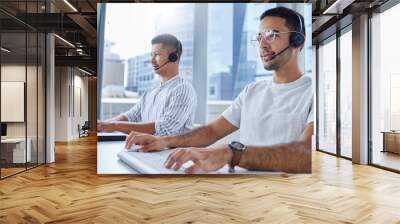 Together well go further. Shot of two business colleagues working together at their desks in their office. Wall mural