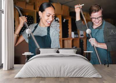 Winemaker workers in wine production using press tool for mixing or pressing in a warehouse, winery or distillery. Teamwork people, woman and man working on quality alcohol, manual labor in a cellar Wall mural