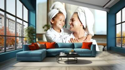 Happy, smiling and relaxed mother and daughter spa day at home with face masks for healthy skincare and personal hygiene. Cute little girl and parent bonding and enjoying a pamper treatment together Wall mural