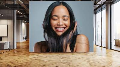 I always give my hair all the nutrients it needs. Studio shot of an attractive young woman posing against a grey background. Wall mural