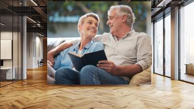 Senior, couple and pension people reading with a happy smile in a home living room sofa. Retirement of elderly man and woman smiling with calm happiness on a house couch with a book together Wall mural