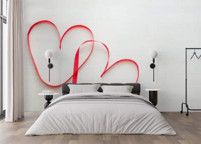 Two red ribbons shaped as heart on wood table Wall mural