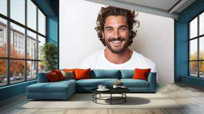 Man in his 30s with long curly hair and a white t - shirt  Wall mural