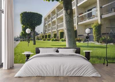 Afternoon shot of trees, grass field and apartment with balcony Wall mural