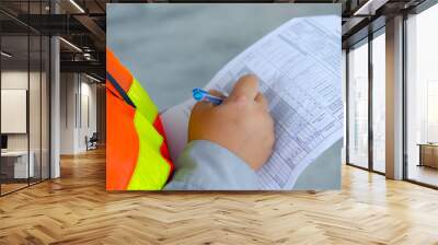 Engineer wear safety equipment write and record inspection report,worker write maintenance check list for preventive maintenance. Wall mural