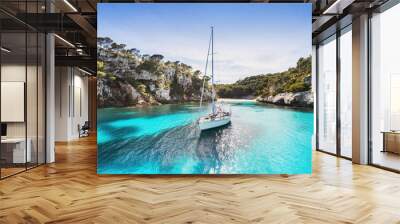 Beautiful beach with sailing boat yacht, Cala Macarelleta, Menorca island, Spain. Yachting, travel and active lifestyle concept Wall mural