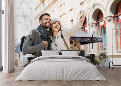 Beautiful happy couple autumn portrait. Young joyful smiling woman and man in a city in winter.  Love, travel, tourism, students concept Wall mural