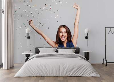 Beautiful happy woman at celebration party with confetti falling everywhere on her. Birthday or New Year eve celebrating concept Wall mural