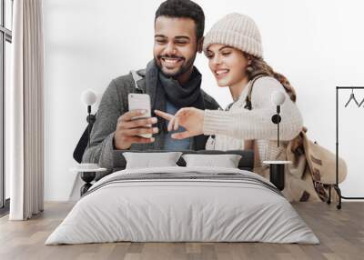 Beautiful happy young couple using smartphone isolated transparent PNG. Joyful smiling woman and man looking at mobile phone. Love, travel, tourism, students lifestyle concept Wall mural