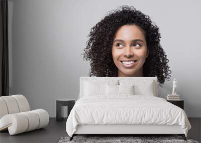 Beautiful young happy woman closeup studio portrait, Smiling cute joyful student girl looking up isolated on gray background Wall mural