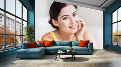 Beautiful young woman portrait. Smiling girl looking at camera and enjoying life at home. Beauty, relaxation, wellbeing, mindfulness concept Wall mural