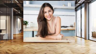 Beautiful young woman relaxing at the kitchen. Happy smiling girl home portrait. Resting, relaxation and leisure concept Wall mural