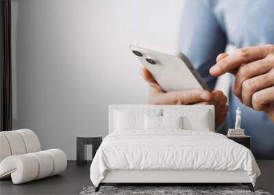 Closeup of adult male hand using mobile phone, Young man texting on smartphone over grey background, panoramic banner with copyspace Wall mural