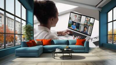 Female employee talk on team video call with colleagues coworkers. Business woman has webcam digital virtual conference at home office, speak in online group meeting. Wall mural