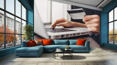 Hand holding credit card and using laptop. Online shopping concept Wall mural