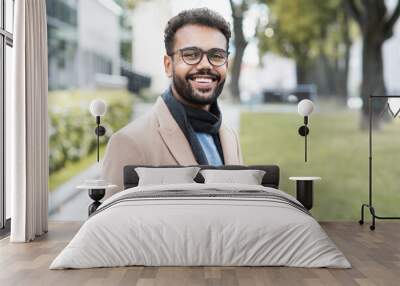 Handsome smiling business man autumn portrait. Joyful men student wearing warm clothes in a city in winter Wall mural