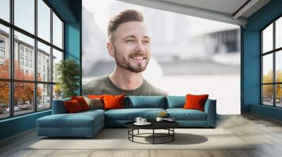 Handsome smiling young man portrait. Cheerful men looking away on city street panoramic banner Wall mural