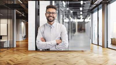 Handsome young businessman with folded arms in the office, Cheerful self confident men with crossed hands portrait, Business success concept Wall mural