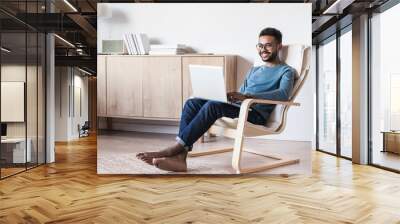 Handsome young man using laptop computer at home. Student men resting  in his room. Home work or study, freelance concept Wall mural