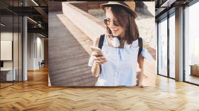 Happy beautiful girl using smart phone in the city, summer girl portrait Wall mural