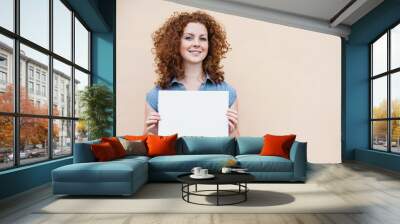 Happy young woman holding blank white banner Wall mural