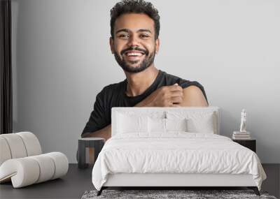 Man smiling after receiving vaccination, young men received a corona vaccine isolated on gray background. Wall mural