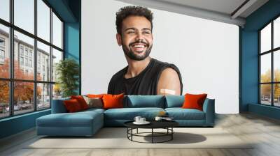 Man smiling after receiving vaccination, young men received a corona vaccine looking away isolated on gray background. Wall mural