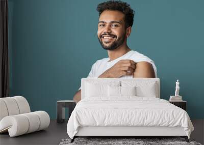 Man smiling after receiving vaccination, young men received corona vaccine studio portrait Wall mural