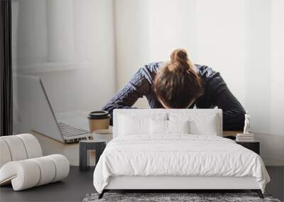 Tired and overworked business woman. Young exhausted girl sleeping on table during her work using laptop, digital tablet and smartphone. Entrepreneur, freelance worker or student in stress concept Wall mural