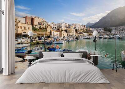 View of Castellammare del Golfo town, Sicily island, Italy. Beautiful mediterranean port with fishing boats over old town background. Popular travel destination in Europe Wall mural