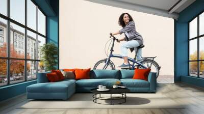 Young beautiful woman on bike over white wall background in a city, Smiling student girl with bicycle smiling outdoor, Modern healthy lifestyle, travel, casual business concept Wall mural