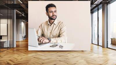 Young handsome man using laptop at home, Businessman or student working online on computer indoors, Freelance, online marketing, distance education, home work and technology concept Wall mural