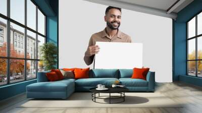 Young man holding blank white board for advertise text isolated on gray background Wall mural