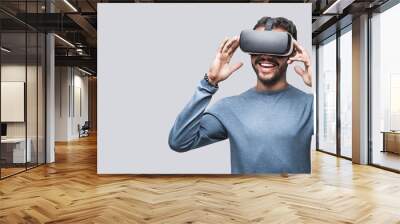 Young man using virtual reality headset isolated over gray background, VR, future, gadgets, technology concept Wall mural