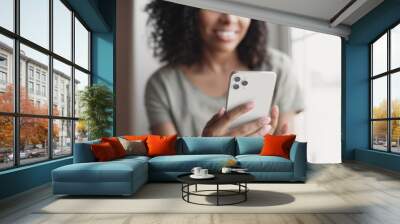 Young woman using smartphone at home. Student girl texting on mobile phone in her room. Communication, home work or study, connection, mobile apps, technology, lifestyle concept Wall mural