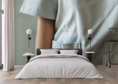 Detail shot of a nurses torso in light gray scrubs, focused on the fabric texture against a soft, neutral backdrop Wall mural