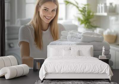 A beautiful woman joyfully organizing a stack of clean towels in a bright laundry room, enjoying the freshness of her laundry routine Wall mural